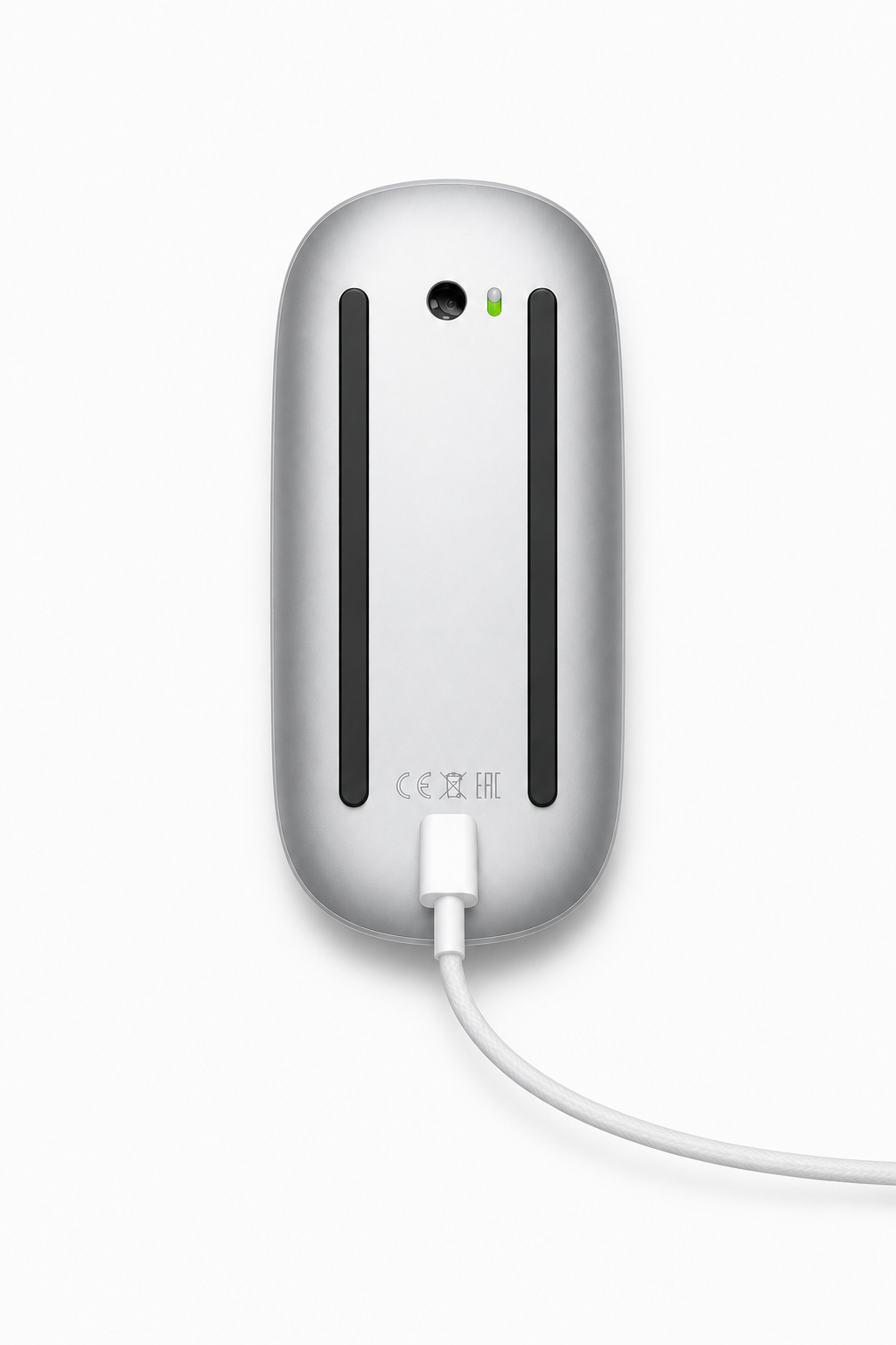 Underside of a silver Magic Mouse connected to a charging cable